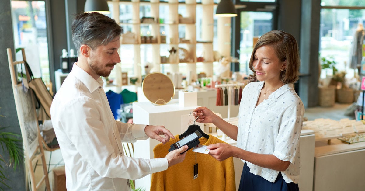 User paying in fashion store with mobile scanning